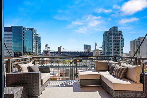 View from a balcony overlooking a cityscape with tall buildings and a distant stadium.