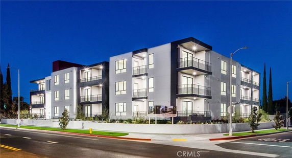 Front view of a modern multi-story apartment building with balconies.