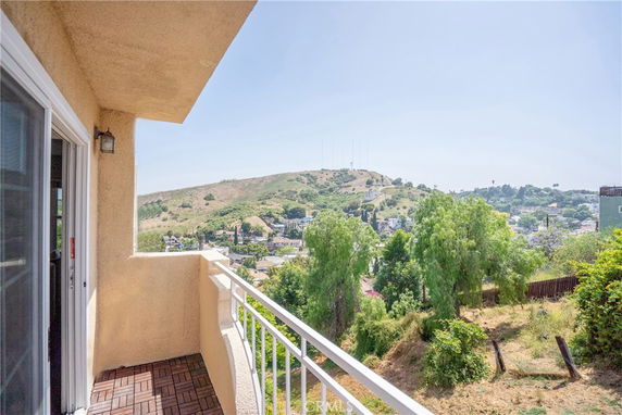 View from a balcony overlooking a hillside and surrounding area.