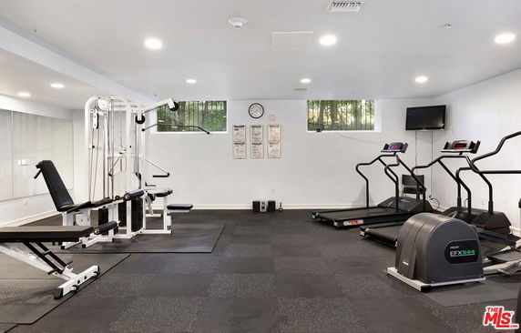 Indoor gym area with exercise equipment including treadmills and weight machines.