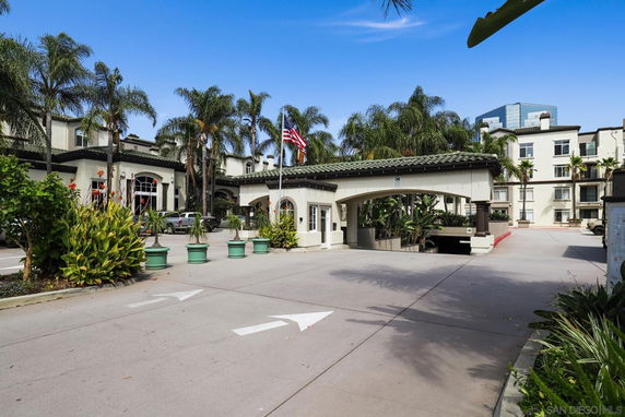 Front view of a multi-story building with a decorated entrance and palm trees.