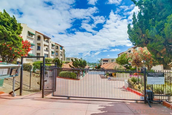 Front view of a multi-story residential building with gated entrance.
