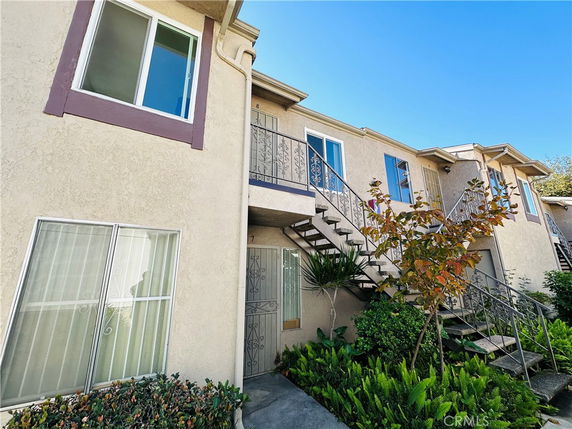 Front view of a two-story residential building with external stairs.