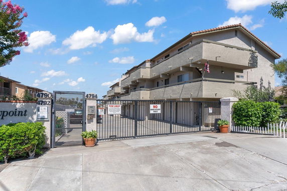 Front view of a multi-story residential building with gated entrance.
