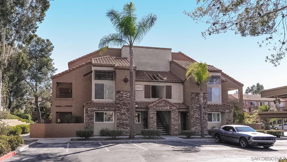 Front view of a multi-story residential building with stone and stucco exterior.