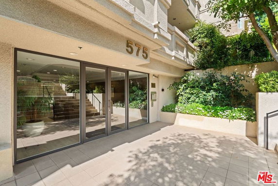 Front view of a building entrance with glass doors and steps leading up.