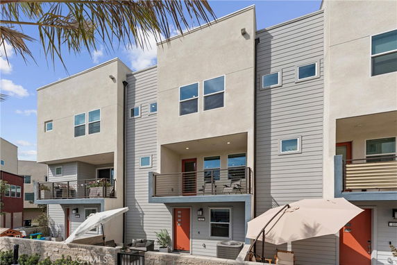 Front view of a modern multi-story building with balconies.