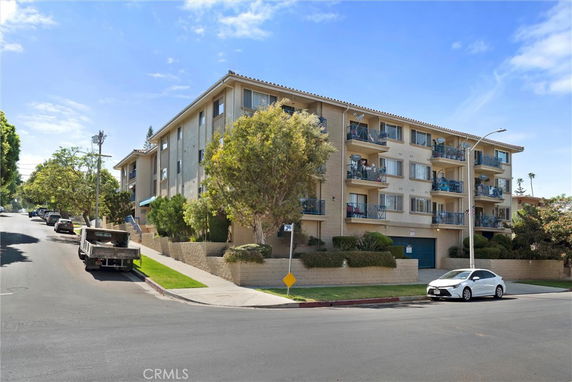 Front view of a multi-story apartment building with balconies.