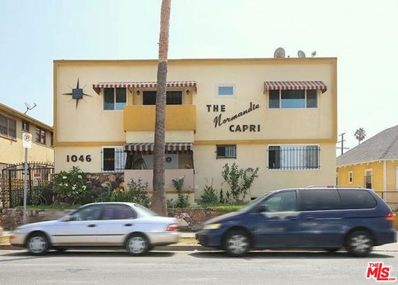 Front view of a two-story building with awnings and a central balcony.