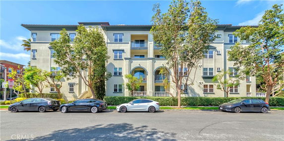 Front view of a multi-story residential building with several windows and balconies.