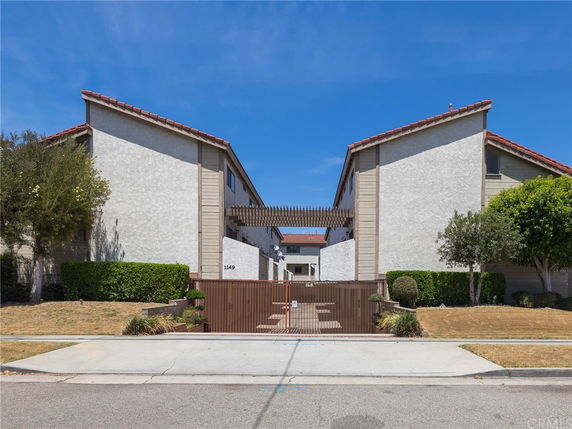 Front view of a two-story residential building with a central gated entrance.