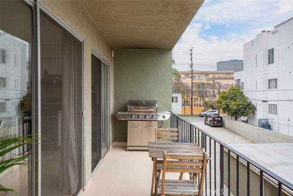 View from a balcony showing surrounding buildings and parking area.