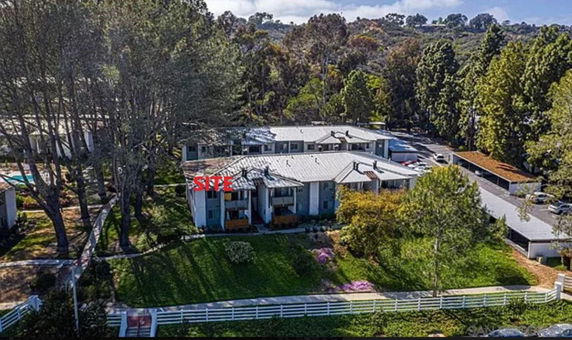 Aerial view of a residential building surrounded by trees and greenery.