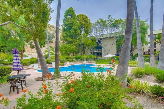 Outdoor swimming pool area surrounded by trees and greenery.