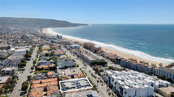 Aerial panoramic view of a coastal cityscape with beachfront and residential areas.