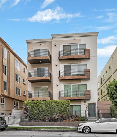 Front view of a modern multi-story apartment building with balconies.