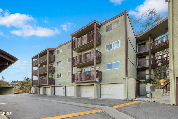 Front view of a multi-story apartment building with balconies.