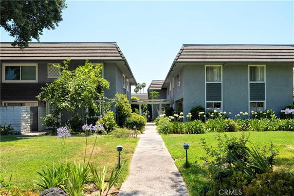 Front view of a two-story residential building with a pathway leading to the entrance.
