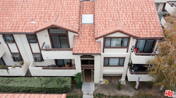 Front view of a multi-story building with red-tiled roof and balconies.