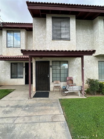 Front view of a townhouse with a small porch and numbered door.