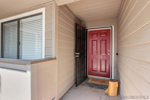Front view of a house entrance with a red door and a window.