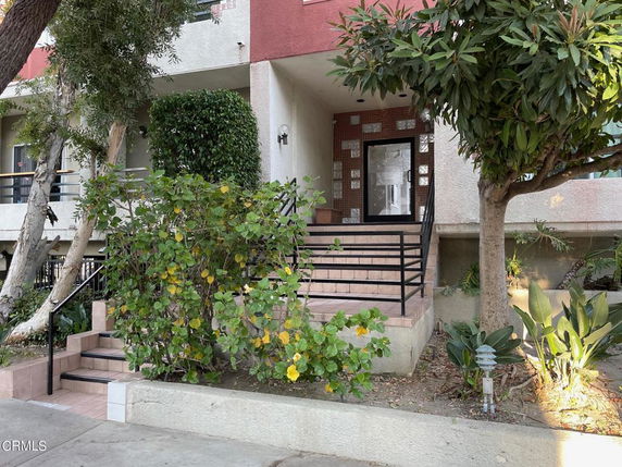 Front view of a multi-story building with steps leading to the entrance.