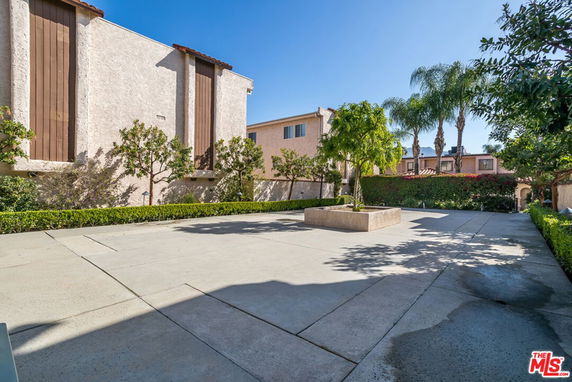 Concrete courtyard area with trees and surrounding residential buildings
