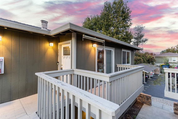 Front view of a house with an elevated entryway and railing.