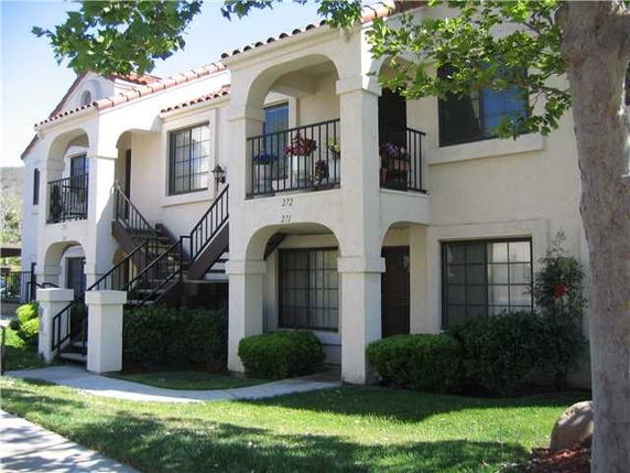 Front view of a two-story residential building with exterior staircases and balconies.