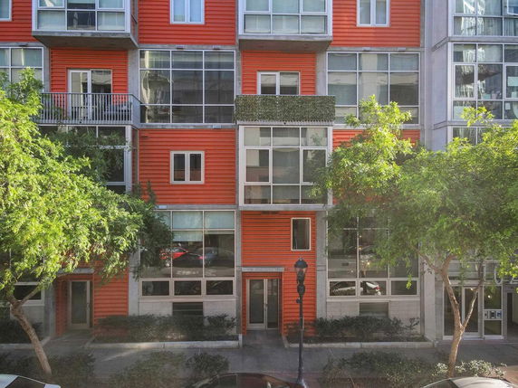Front view of a building with red siding and large glass windows.