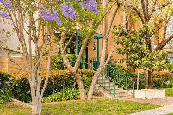 Front view of a building with a staircase and trees.
