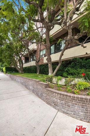 Front view of a multi-story building with balconies and brick facade.
