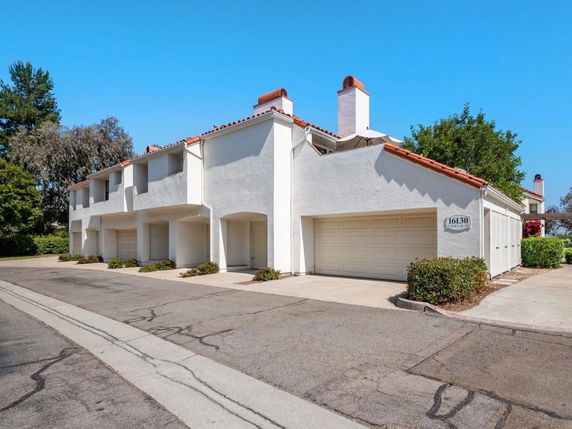 Front view of a white two-story townhouse with garages.