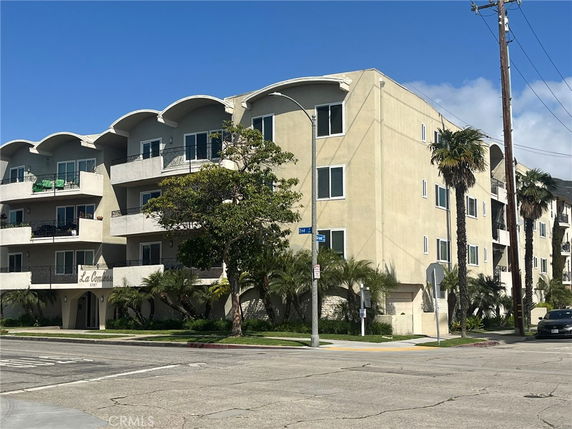 Front view of a three-story apartment building with balconies.
