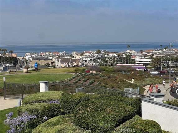 Panoramic view of a coastal town, featuring numerous houses and the ocean in the background.