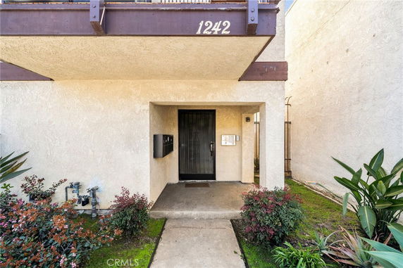 Front view of a building entrance with a covered porch and a black door.