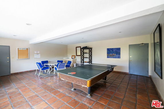 Indoor recreation room with a ping pong table and seating area.