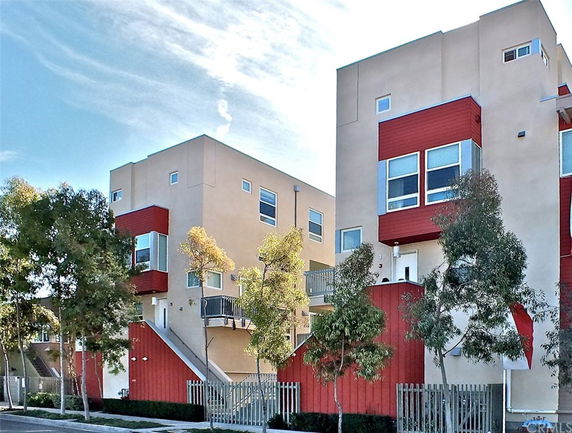 Front view of modern multi-story residential buildings with red and beige color scheme.