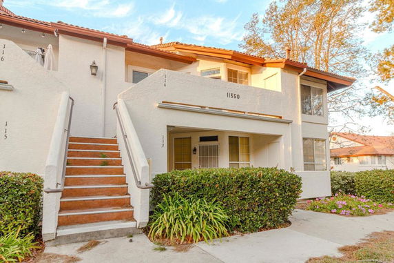 Front view of a two-story residential building with stairs leading to the upper level.