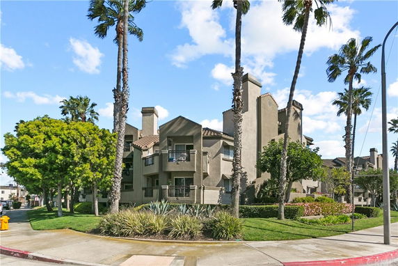 Front view of a multi-story residential building with balconies and multiple chimneys.