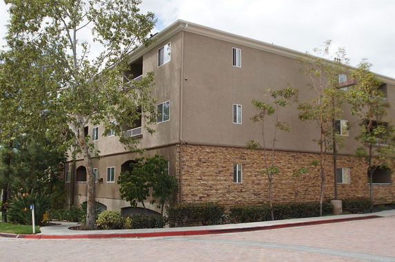 Front view of a multi-story apartment building with brick and stucco exterior.