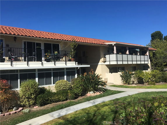 Front view of a two-story building with a tile roof and balconies.