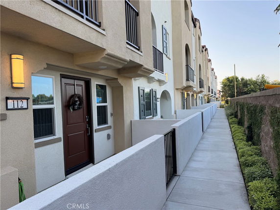 Front view of a row of multi-story townhouses with balconies.
