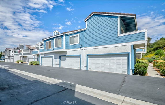 Front view of multi-story houses with garages.