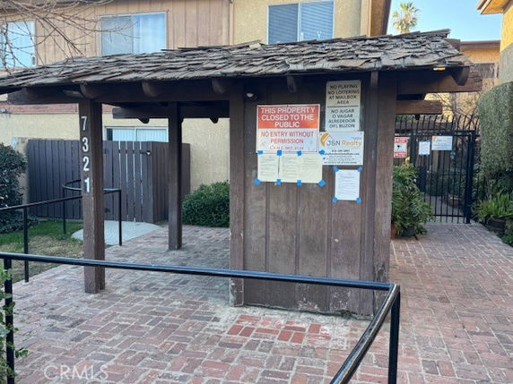 Front view of a building entrance with signage and wooden canopy.