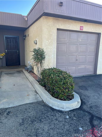 Front view of a building with a single garage and an entrance door.