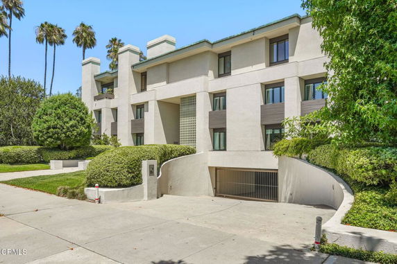 Front view of a multi-story apartment building with a gated entrance.