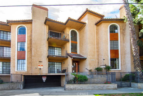 Front view of a multi-story residential building with balconies and large windows.