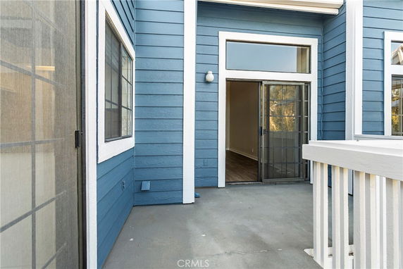 Front view of a building with blue siding and sliding glass door.