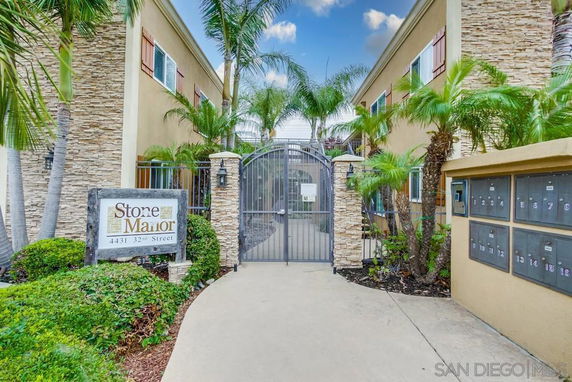 Entrance view of a residential building with a gated entry and mailbox area.